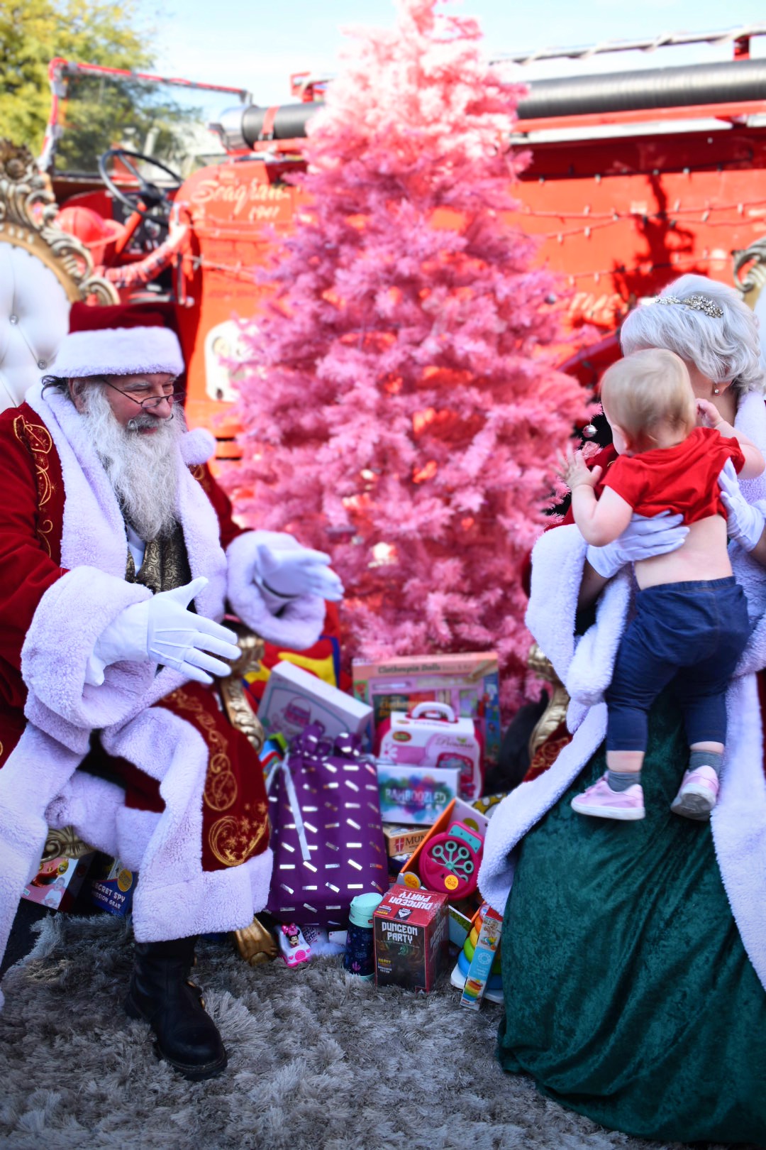 Santa and Mrs. Claus holding a child